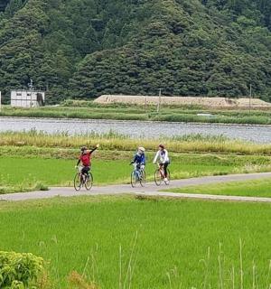 三个人在河边的小路上骑自行车