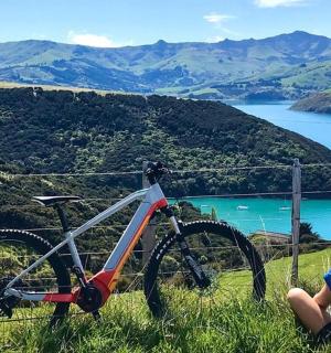 一个男孩坐在山上的一辆自行车旁边