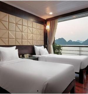 two beds in a room with a view of the water