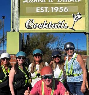 一群戴着头盔的人站在标志牌下