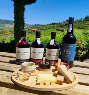 drei Flaschen Wein und Käse auf einem Holztisch