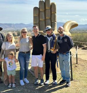 a family posing for a picture in front of a monument