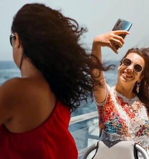 žena fotící jinou ženu na lodi