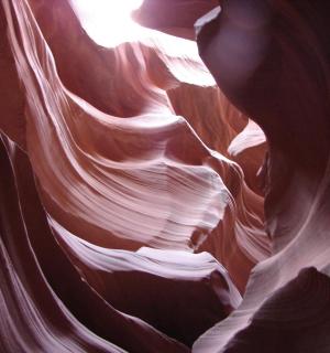 a view of a slot canyon with the sun in it