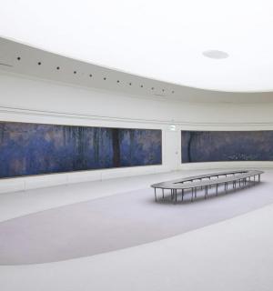 an empty room with two tables and blue paintings