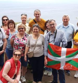 skupina lidí pózujících pro fotografii s vlajkou