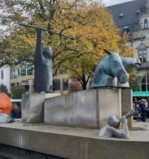 a statue of people and horses on a fountain