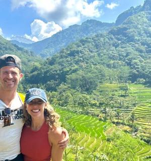 a man and a woman standing in front of a mountain