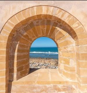 an archway with a view of the ocean