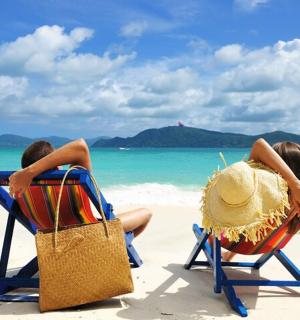 dva lidé sedící v plážových lehátkách na pláži