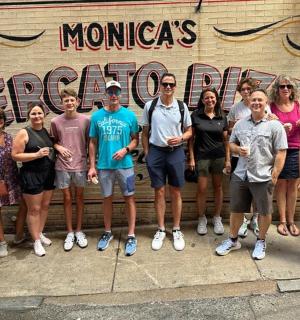 skupina lidí stojící před cedulí