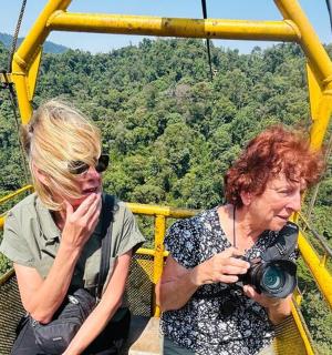 两名女子带着相机在滑索上