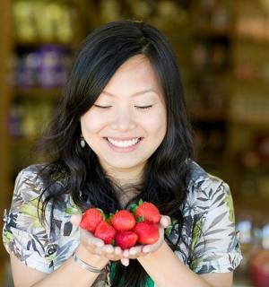 žena drží hrozen jahod