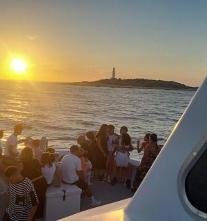 a group of people on a boat watching the sunset