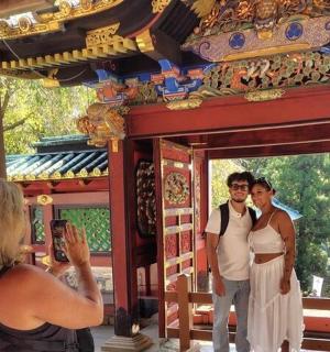 一名女子在寺庙里为两个人拍照