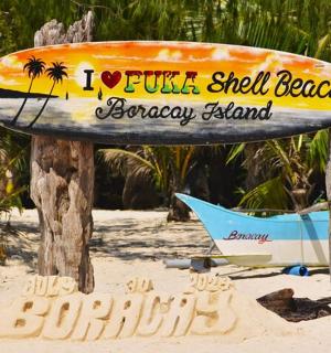 海滩上的一个标志，上面有一块冲浪板