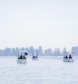 skupina lidí jezdících na malých lodích ve vodě