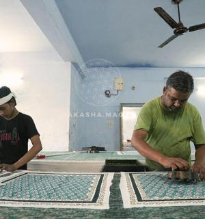 Dva muži pracují na mozaikách na stole