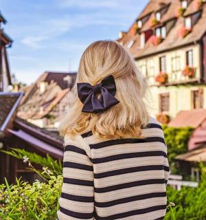 一位头发上戴着蝴蝶结的女人望着一座小镇