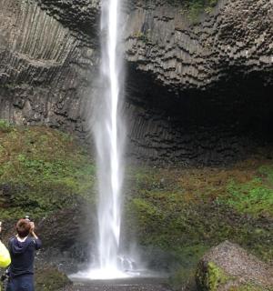 dva lidé stojící před vodopádem