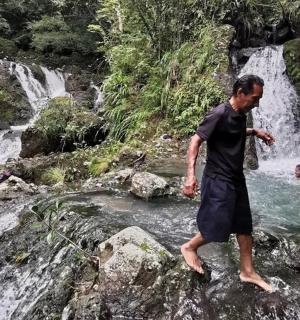 一名男子站在瀑布附近的岩石上