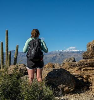一位背着背包站在山顶上的女人