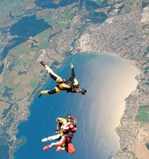 two people are flying in the air over a lake
