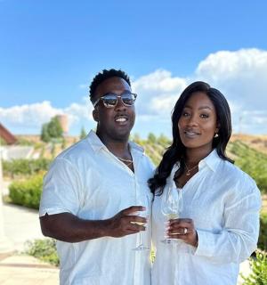 a man and a woman standing in front of a house