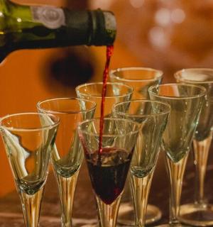 a group of wine glasses with wine being poured into