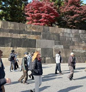 一群人沿着石墙行走