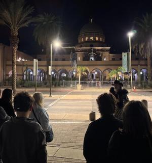 一群人晚上站在一栋建筑前