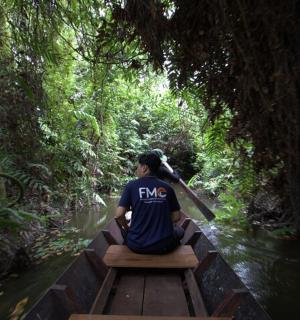 a person riding a boat down a river in the jungle