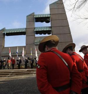 Skupina mužů v červených uniformách stojících před budovou