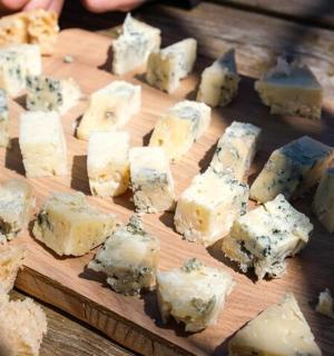 a bunch of cheese on a wooden cutting board