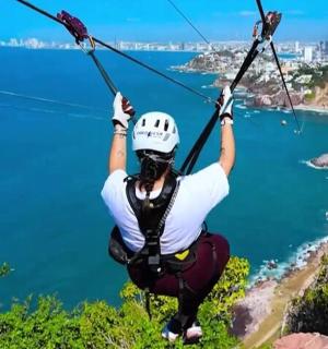 a person on a zip line over the ocean