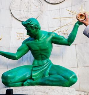 eine Person, die ein Foto von einer grünen Statue macht