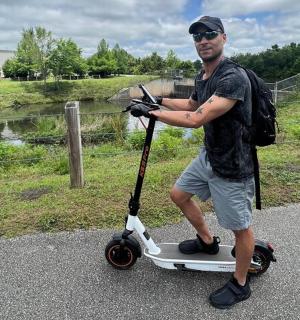 一名男子站在路上的摩托车上