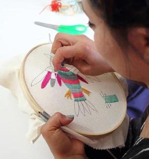 a woman is drawing on a plate with scissors