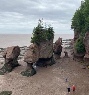 两个人站在海滩上靠近一些岩石的地方