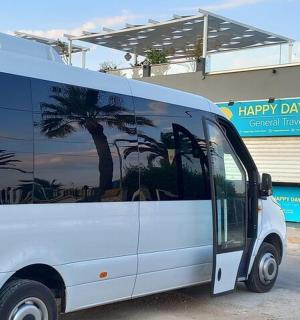 一辆白色货车停在一栋种有棕榈树的建筑物前