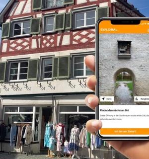 a person holding up a cell phone in front of a building