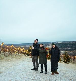 a group of people standing in front of a vineyard