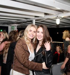 kaks naist poseerivad rahvamassis pildi jaoks