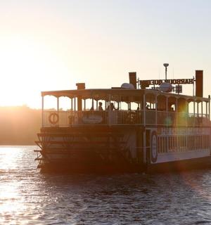 a ferry boat on the water at sunset