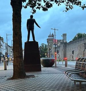 一座城市中坐在基座上的男子雕像