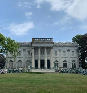 a large white building with flowers in the yard