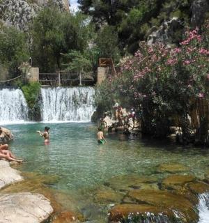 a group of people in a swimming pool with a waterfall