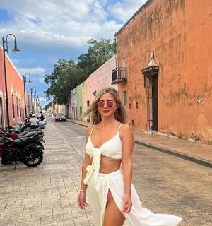 一位身穿白色连衣裙的女子走在街上