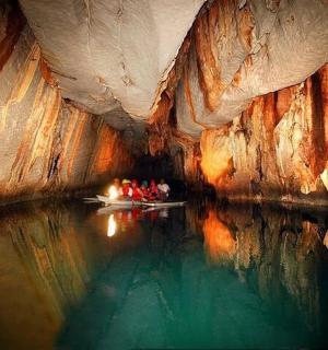 a group of people in a boat in a cave