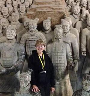 a woman standing in front of a statue of people